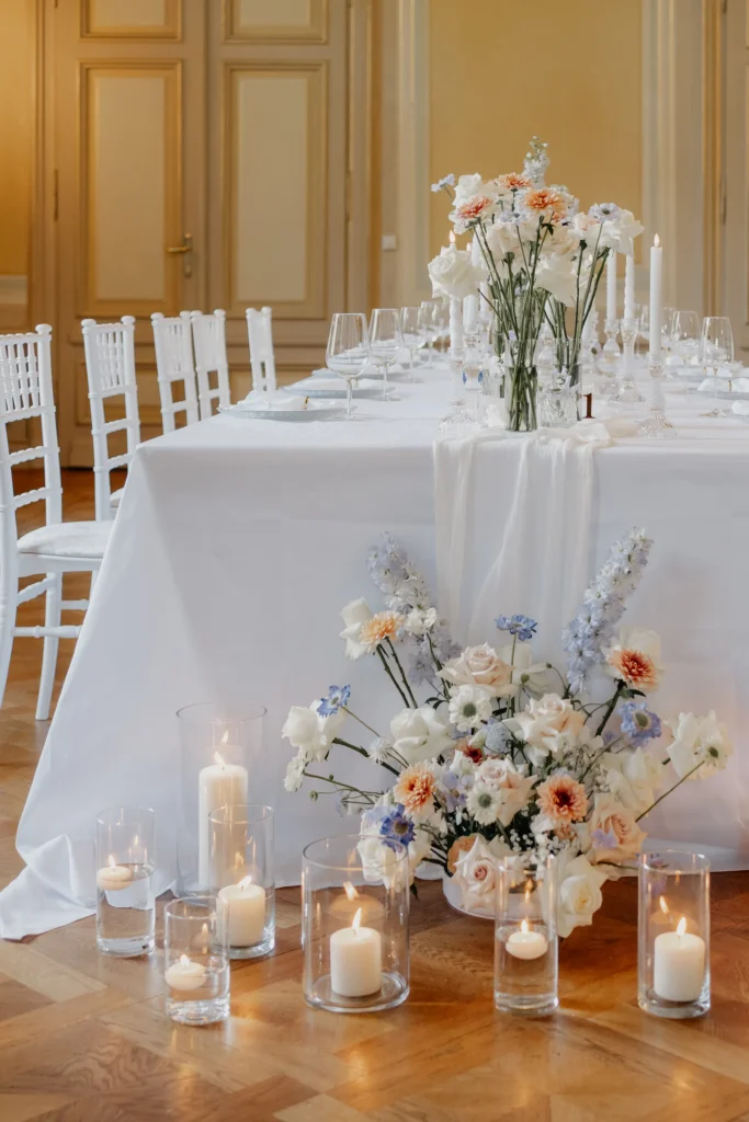 Stilvoll gedeckter Hochzeitstisch mit Blumen und Kerzen.
